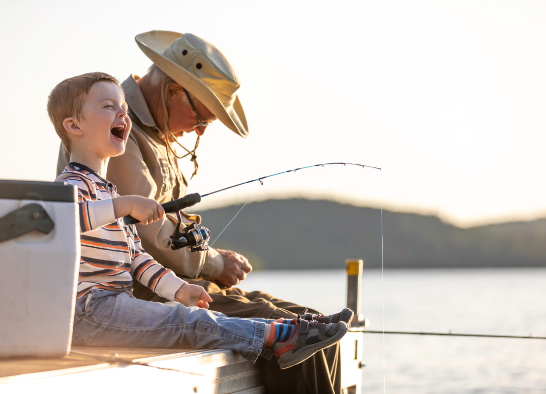 a kid with his grandfather are fishing
